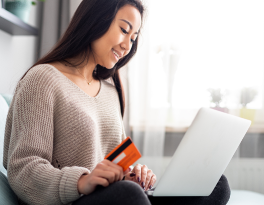 asian girl making online payment using laptop