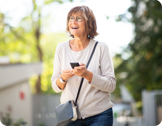 Happy older woman laughing with mobile phone